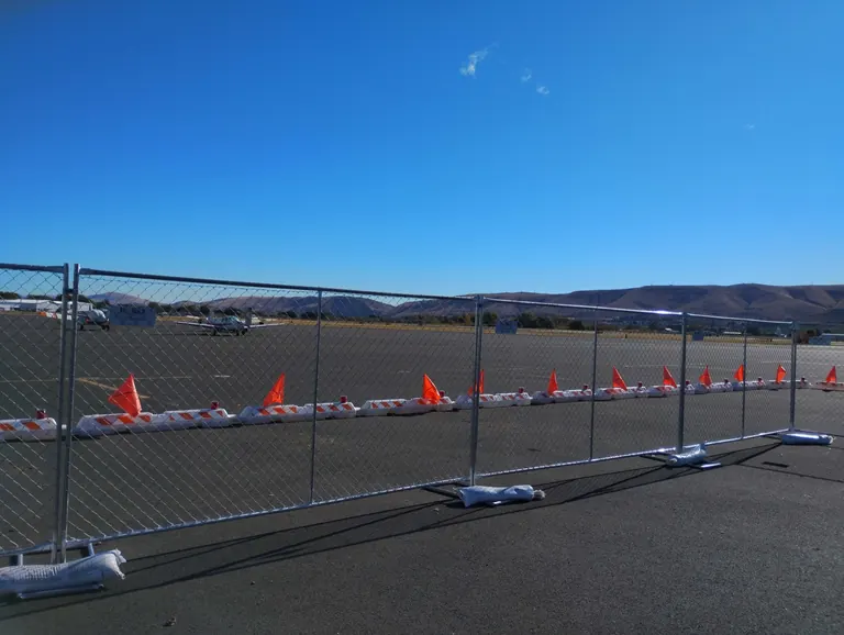 Temporary chain-link fence panels on T-stands with sandbags at a Yakima, Washington project