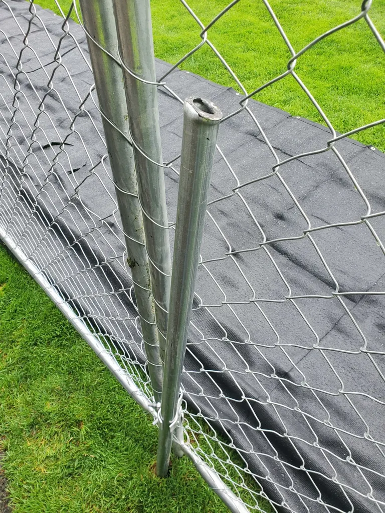 Close view of a temporary fence panel connected beside a driven post in Kennewick
